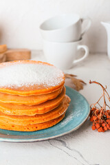 Tasty pumpkin pancakes on table