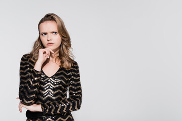 pensive young woman looking away isolated on grey