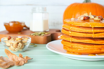 Tasty pumpkin pancakes on table