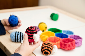 Colorful beehive with bees. Crochet safe toys for babies. Processed egg craft ideas are a bright Easter-colored rainbow-colored educational toy. Preschool game for young children. Montessori education