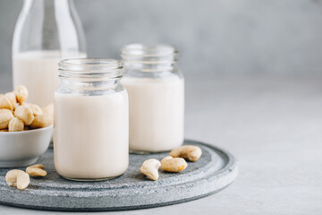 Cashew Nut Milk in glass on gray stone background