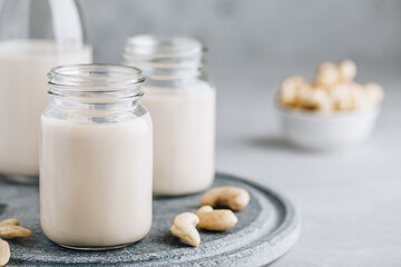 Cashew Nut Milk in glass on gray stone background
