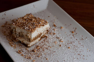 Tiramisu Dessert. Classic Italian dessert. Lady fingers soaked in syrup, espresso and layered with cream, nuts and powdered sugar.