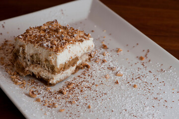 Tiramisu Dessert. Classic Italian dessert. Lady fingers soaked in syrup, espresso and layered with cream, nuts and powdered sugar.