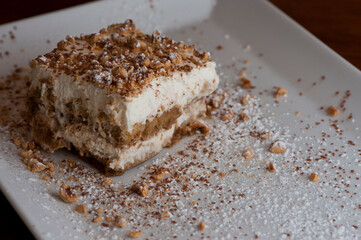 Tiramisu Dessert. Classic Italian dessert. Lady fingers soaked in syrup, espresso and layered with cream, nuts and powdered sugar.