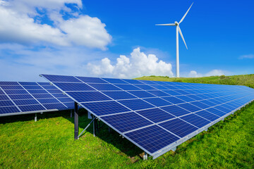 solar panels and a wind turbine against a blue sky