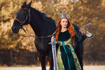 a Queen in a long green dress with a sword and crown and a horse