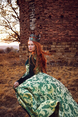 Queen with red hair in a green dress with a crown and a sword