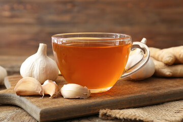 Cup of healthy garlic tea on table