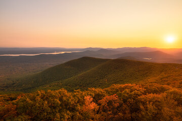 Warm golden sunlight shining across layers of rolling mountains during sunset. Overlook Mountain,...