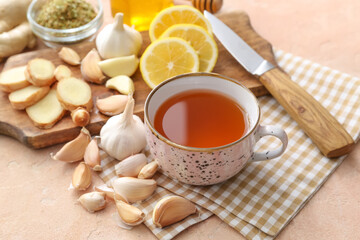 Obraz na płótnie Canvas Cup of healthy garlic tea on color background