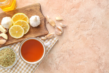 Cup of healthy garlic tea on color background