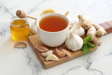 Obraz na płótnie Canvas Cup of healthy garlic tea on white background