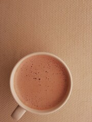 
glass of milk and hot chocolate with milk froth on a beige background