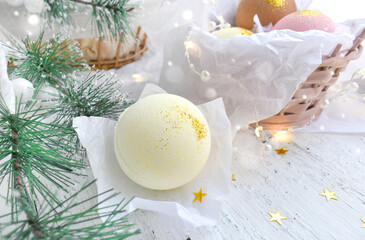 Wintertime spa concept with bath bombs, fir tree branch on white.  Nature aromatherapy pampering. ...
