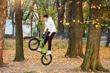 Park , a teenager boy jumps high on a bicycle. Extreme sport.