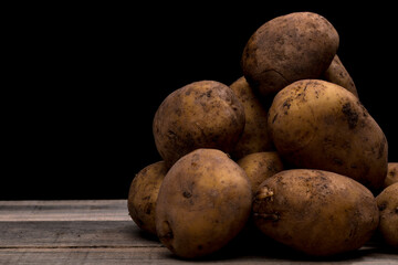 potatoes on a wooden floor, potatoes waiting to be peeled or washed