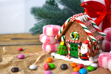 Christmas gingerbread house with candies over holiday background. Home decorated composition with copyspace.
