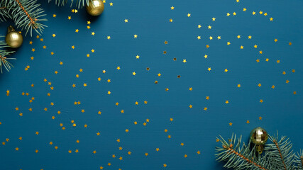 Christmas frame mockup. Fir tree branches decorated golden balls and confetti on blue background....