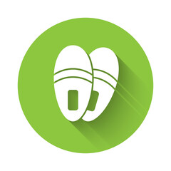 White Slippers icon isolated with long shadow. Flip flops sign. Green circle button. Vector.