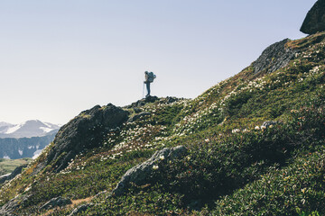 Solo traveling girl hiking with backpack in mountains adventure journey