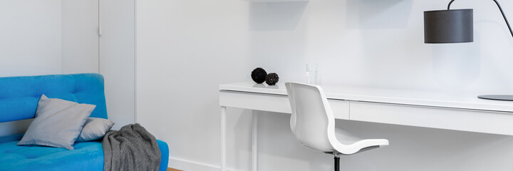 White room with desk and couch, panorama