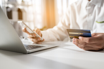 Close up hand man using credit cards for shopping online. Businessman use credit cards to conduct...