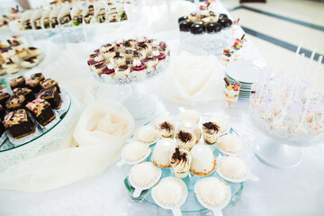 Delicious and tasty dessert table with cupcakes and shots at reception closeup