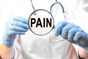 The doctor's blue - gloved hands show the word PAIN - . a gloved hand on a white background. Medical concept. the medicine