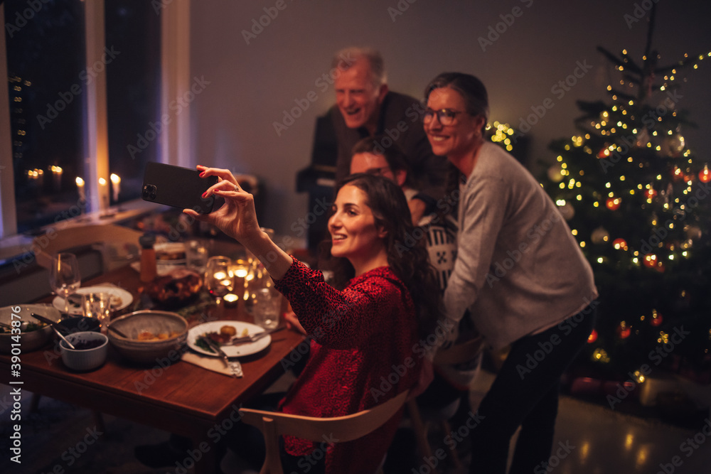 Wall mural Family doing video call during Christmas dinner