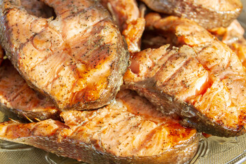 Grilled red fish trout steaks lie on a glass plate