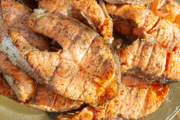 Grilled red fish trout steaks lie on a glass plate