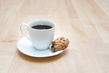 Cup of coffee with  chocolate cookie on wooden background