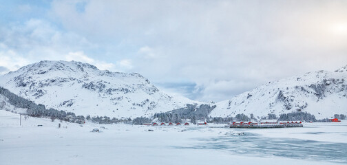 Winter scene with traditional Norwegian red wooden houses on the shore of Rolvsfjord in Valberg on Vestvagoy island at Lofotens