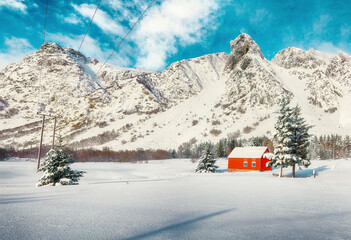 Astonishing winter scenery with traditional Norwegian wooden houses and pine trees near Valberg village at Lofotens.