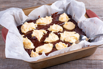 Ready to bake tow types of dough chocolate and shortbread for home baking trend dessert brookies brownies and cookies in baking tray on a wooden table.