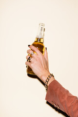 cropped view of woman holding bottle with beer on white