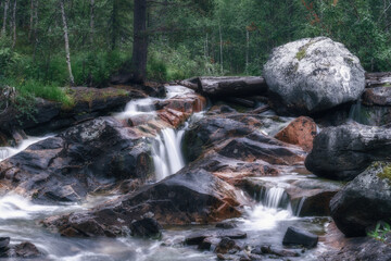 Waterfall on the forest river in the Polar Region. River in a dense forest