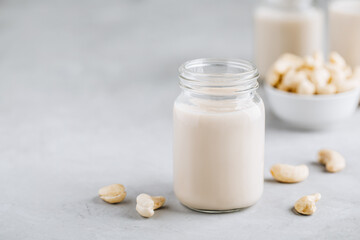 Cashew Nut Milk in glass on gray stone background