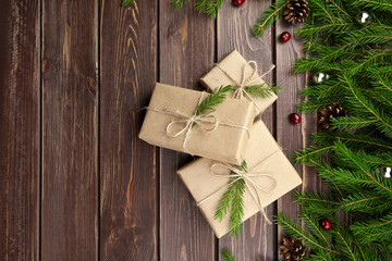 Christmas gift boxes with fir tree branches on wooden background