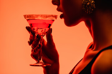 cropped view of woman drinking margarita cocktail on orange - Powered by Adobe