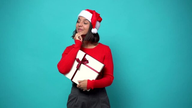 woman smiling and looking to the front with confident face in christmas holidays and holding a gift