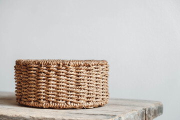 Empty round wicker basket on a old wooden table. Copy, empty space for text