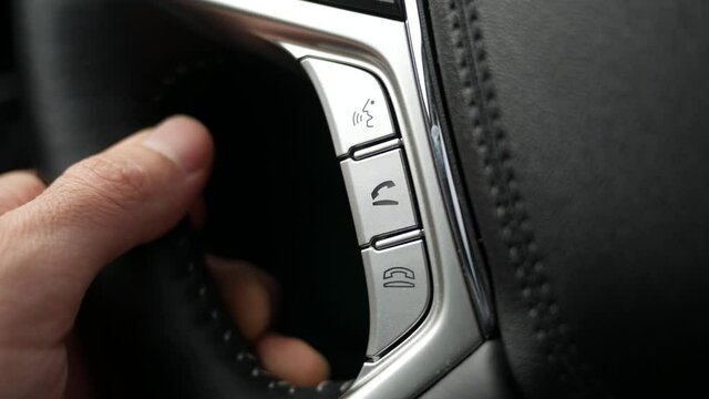 Using the buttons on the car steering wheel to answer a call.
