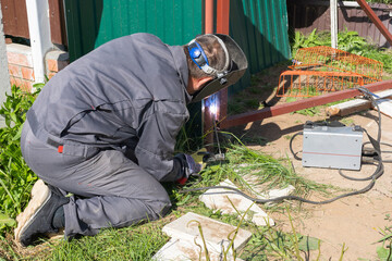 A man works with an inverter welding machine