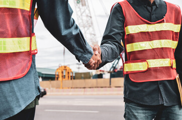 Fototapeta premium Two engineers shaking hands on a working project