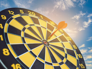 red darts arrows in the center of dartboard with blue sky background, in the business goal concept