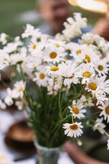 Obraz premium A bouquet of wild flowers in a vase on a table in the garden