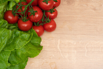 Succulent tomatoes and fresh lettuce with copyspace on board