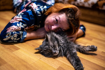 woman playing with her beloved gray cat